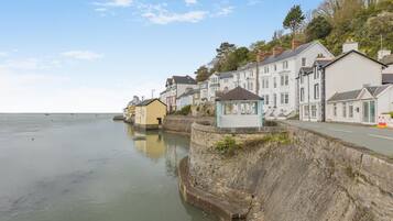 A coastal town with stone walls, a promenade, and traditional buildings along the water.