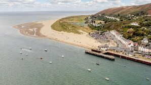 Un pueblo costero con playa, muelle y edificios residenciales.