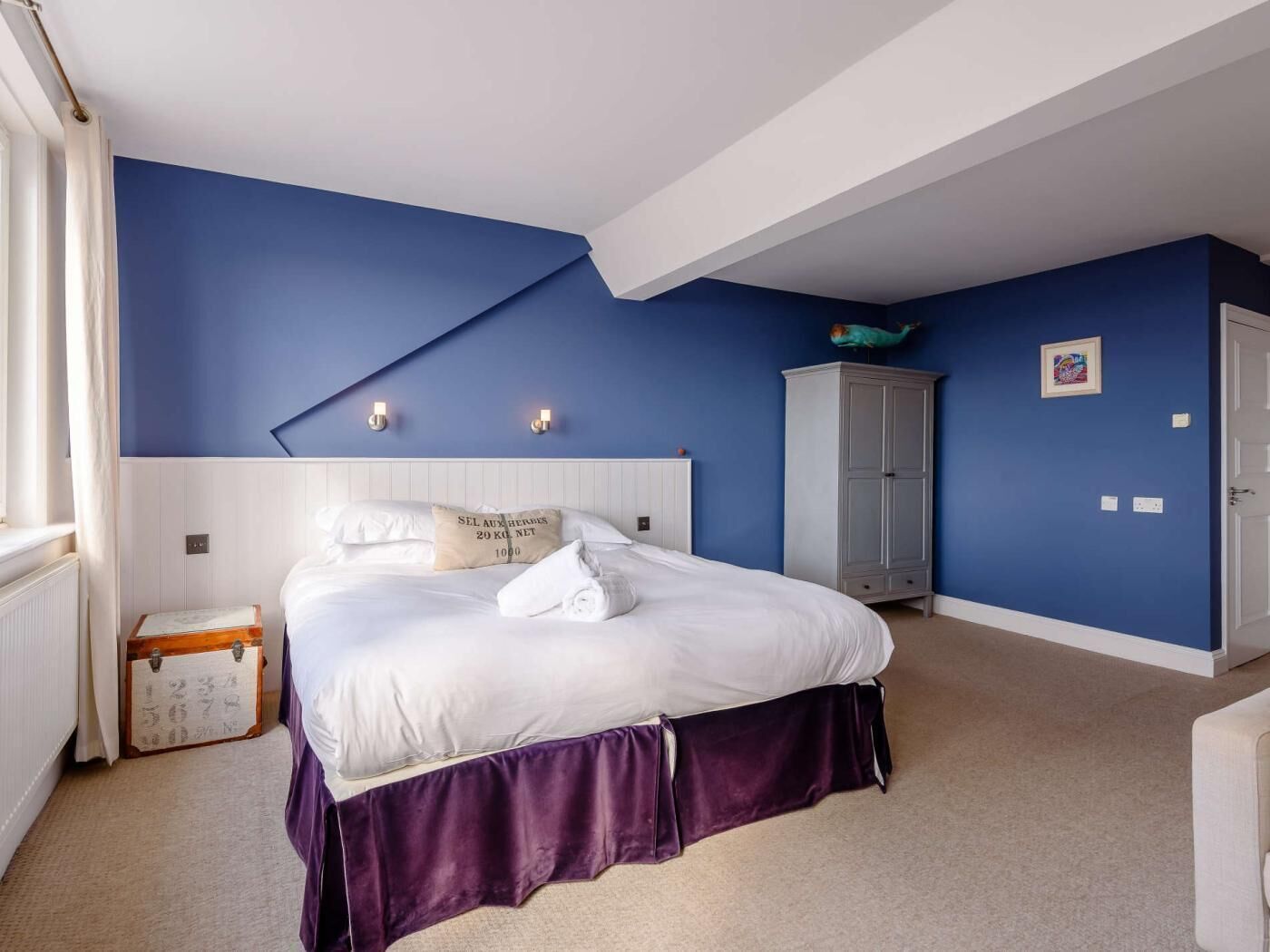 Een slaapkamer met een bed, een kledingkast en een kast.
