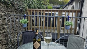 A round glass table with a bottle of organic prosecco and a glass of wine on a balcony. - 2 Bed in Aberdyfi (oc-dy047) (Aberdovey)