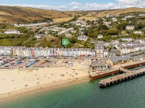 A coastal town with a beach, a pier, and colorful buildings. - 2 Bed in Aberdyfi (oc-dy044) (Aberdovey)