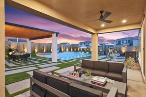 Eine Außenpatio-Terrasse mit Pool, Sitzgelegenheiten und Blick auf umliegende Häuser.