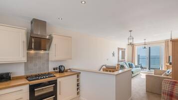 A modern kitchen with built-in appliances, a dining area with a view, and a cozy seating space.