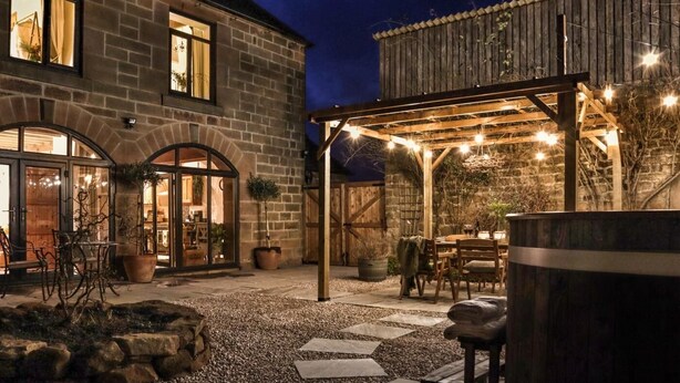 A stone building with a covered patio area, outdoor seating, and a hot tub. - 3 Bed in Matlock (oc-86482) (Hackney)