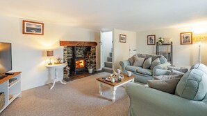 A cozy living room with a stone fireplace, a television, a sofa, and a coffee table. - 2 Bed in Umberleigh (oc-86611) (Cobbaton)