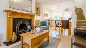 A modern living room with a fireplace, a dining area, and a kitchen. - 1 Bed in Keswick (oc-86560) (Keswick)