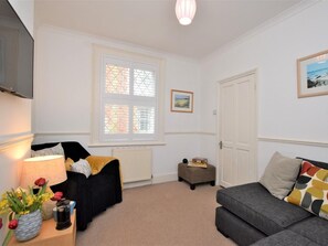 A room with a bed, a sofa, a small table with a lamp, and a radiator. - 2 Bed in Ventnor (oc-86509) (Ventnor)