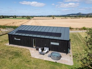 Un bâtiment moderne doté d’un toit plat, de panneaux solaires, d’un jacuzzi et d’un espace patio.
