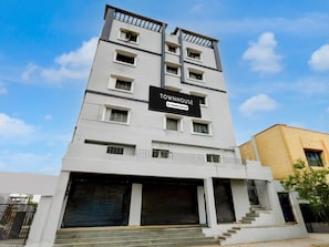 A multi-story building with a sign reading 'TOWNHOUSE' and a company-serviced logo. - Super Deluxe Roomvanasthalipuram (Hyderabad)