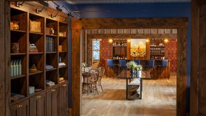 A wooden interior with a bar area, shelves with various items, and a dining table. - Tumbling River Ranch (Grant)