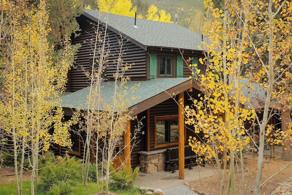 A log cabin with a porch and a stone fireplace.