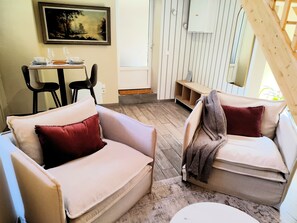 Un salon chaleureux avec deux canapés, une table à manger et un tableau accroché au mur.
