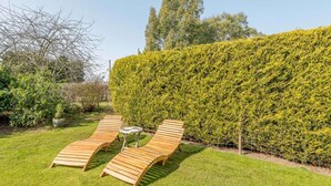 A garden with wooden loungers and a hedge. - 2 Bed in Louth (oc-86797) (Fotherby)