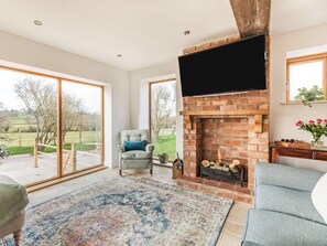 A living room with a fireplace, a large window, and a view of the outdoors. - 3 Bed in Pershore (oc-86760) (Eckington)