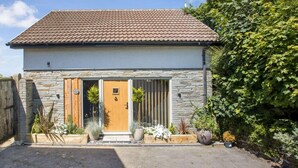 Ein modernes Haus mit Steinaußenwand, Holztür und Ziegeldach.