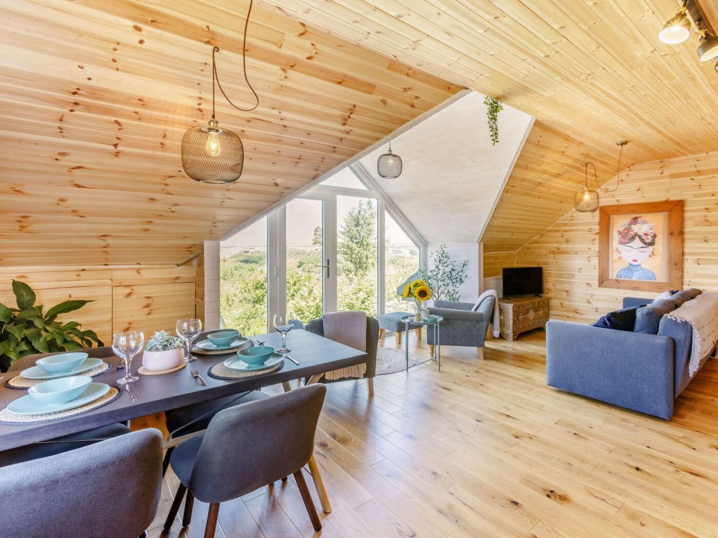Un intérieur chaleureux et rustique, avec une salle à manger, des sièges et un téléviseur.