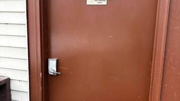 A brown door with a brass number plate reading '303' and a sign stating 'This is a non-smoking room.'