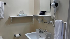 Un baño con inodoro, lavabo, toallero y secador de pelo.