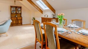 A dining area with a high ceiling, skylights, wooden furniture, and a view of the sky. - 2 Bed in Ilfracombe (oc-86940) (Berrynarbor)
