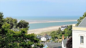 Vista costeira com casas, árvores e uma praia.