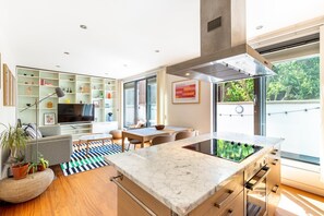 Una cocina moderna con una isla grande, electrodomésticos integrados y un comedor con vistas.