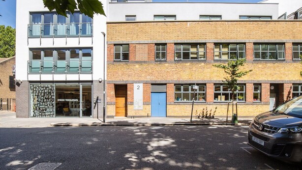 A modern building with a brick facade, large windows, and a blue door. - Bright Lambeth Apartment by Waterloo (London)