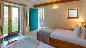 Een slaapkamer met een bed, een stoel, een tafel en uitzicht op de omgeving.
