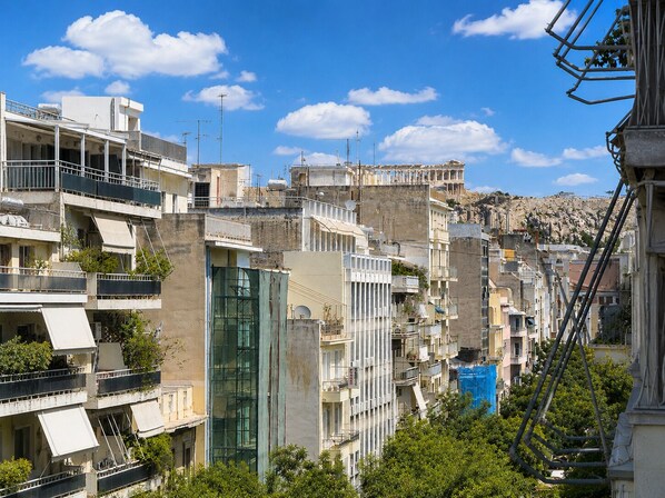 A densely packed urban area with multi-story buildings, some with balconies and terraces, under a clear sky. - Athens Acropolis Balcony  (Athina)