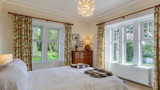 A bedroom with a bed, a dresser, a lamp, and a window with curtains. - 2 Bed in Kirriemuir (oc-86235) (Logie)
