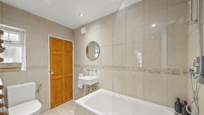 Un baño con inodoro, lavabo y bañera.