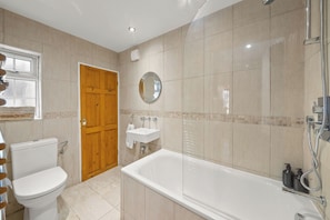A bathroom with a toilet, sink, and bathtub.