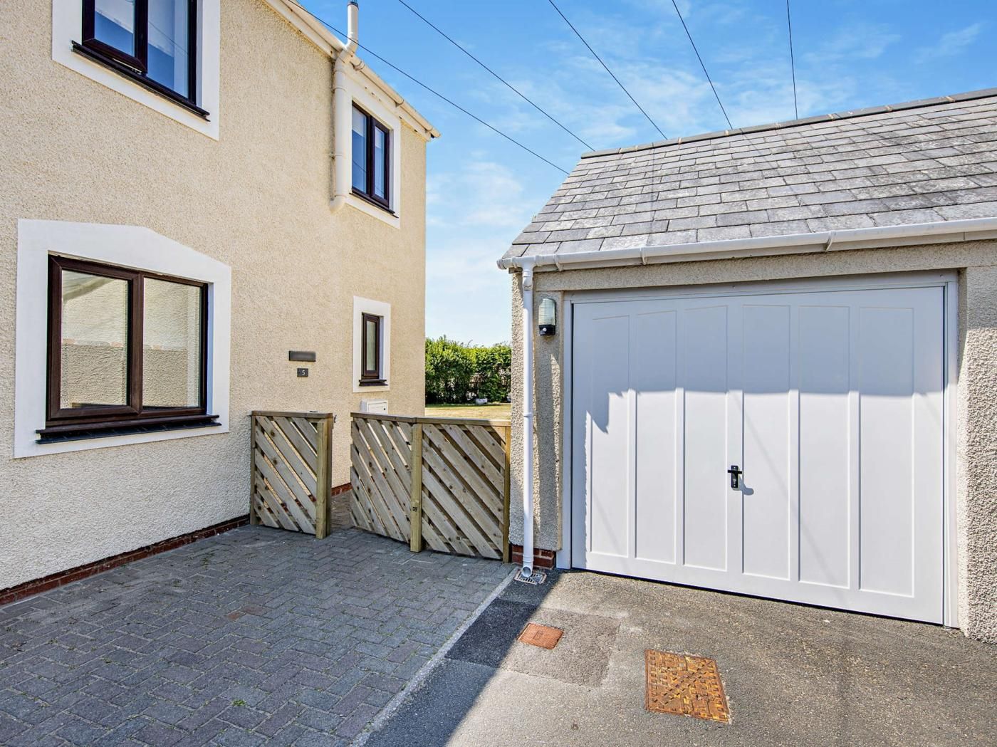 A residential property with a garage, a paved driveway, and a wooden fence.