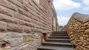 Eine Steintreppe führt zu einem Gebäude mit einer Steinaußenseite.