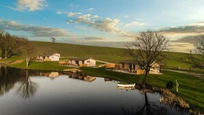 A lakeside property with a house, a boat, and a grassy landscape. - 2 Bed in Castle Douglas (oc-86449) (Auchencairn)