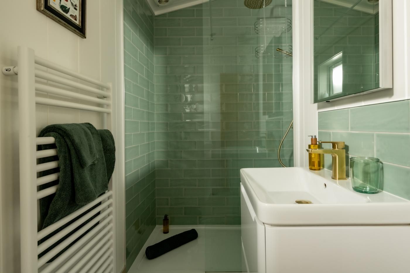 A bathroom with a shower, a white sink, and a towel rack.
