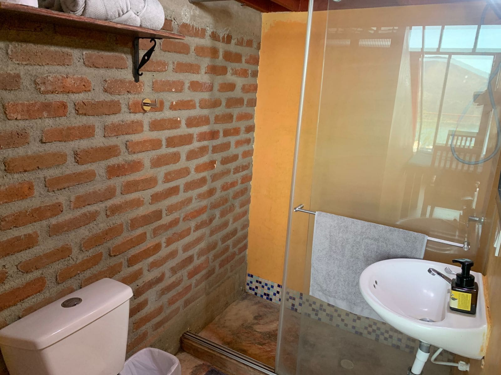 A bathroom with a toilet, a sink, and a shower area.
