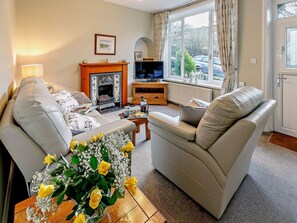A living room with a fireplace, sofa, television, and a window with curtains. - 2 Bed in High Peak (oc-86413) (Whitehough)