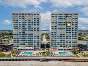 Un hotel moderno con piscina, varios balcones y vistas del entorno.