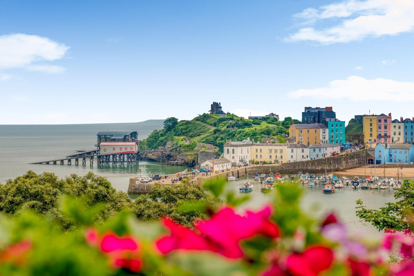 A coastal town with colorful buildings, a pier, and boats in the water.