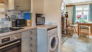 Een kleine keuken met een magnetron, broodrooster en een wasmachine.