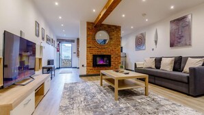 Uma sala de estar moderna com lareira, televisão, sofá e mesa de centro.