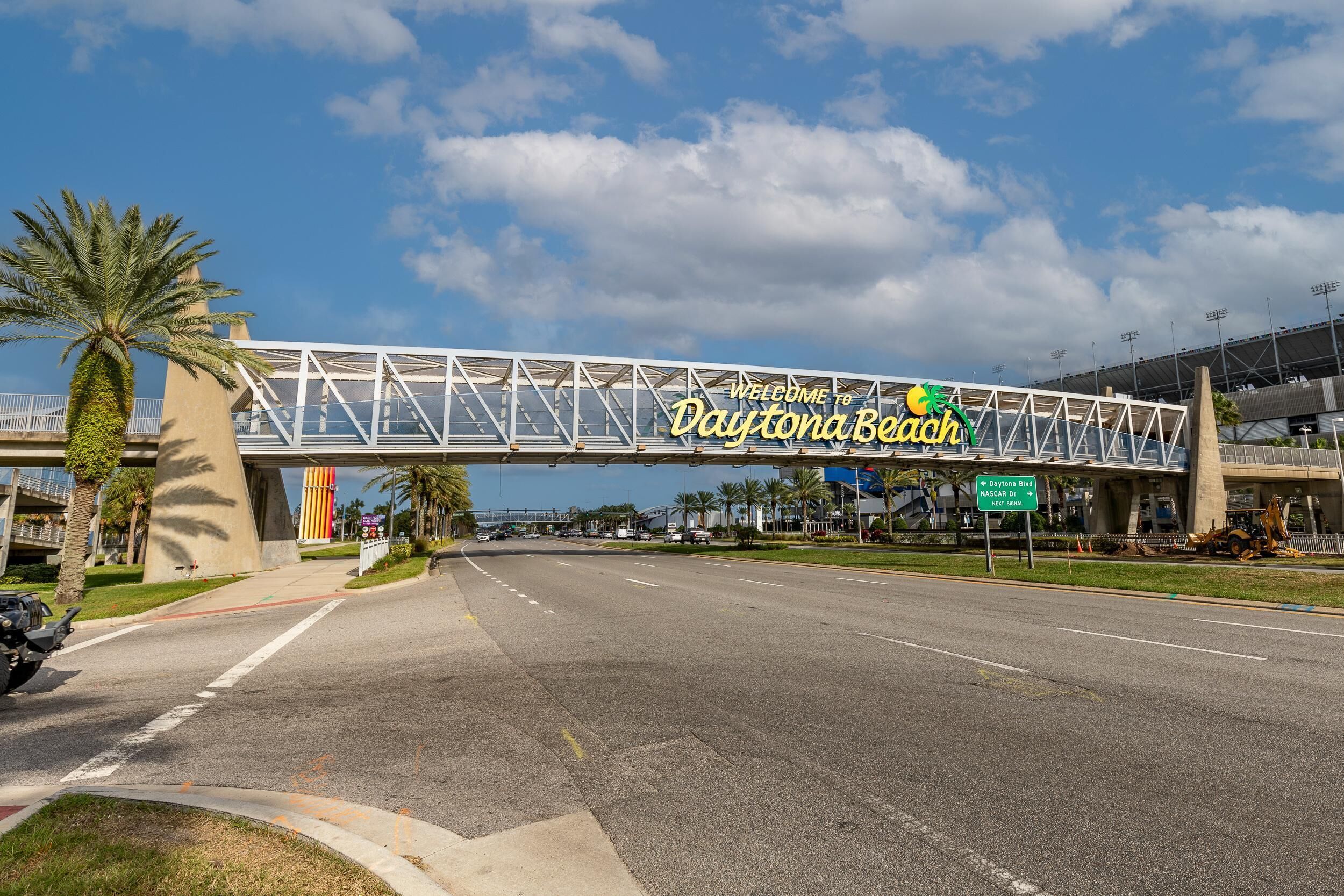 A large overpass with a sign reading "Welcome to Daytona Beach" and a road beneath it.