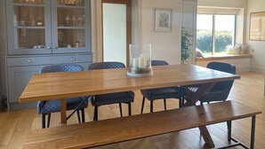 Ein Essbereich mit Holztisch und -stühlen, einer Vitrine mit Glastüren und einer hängenden Pendelleuchte.