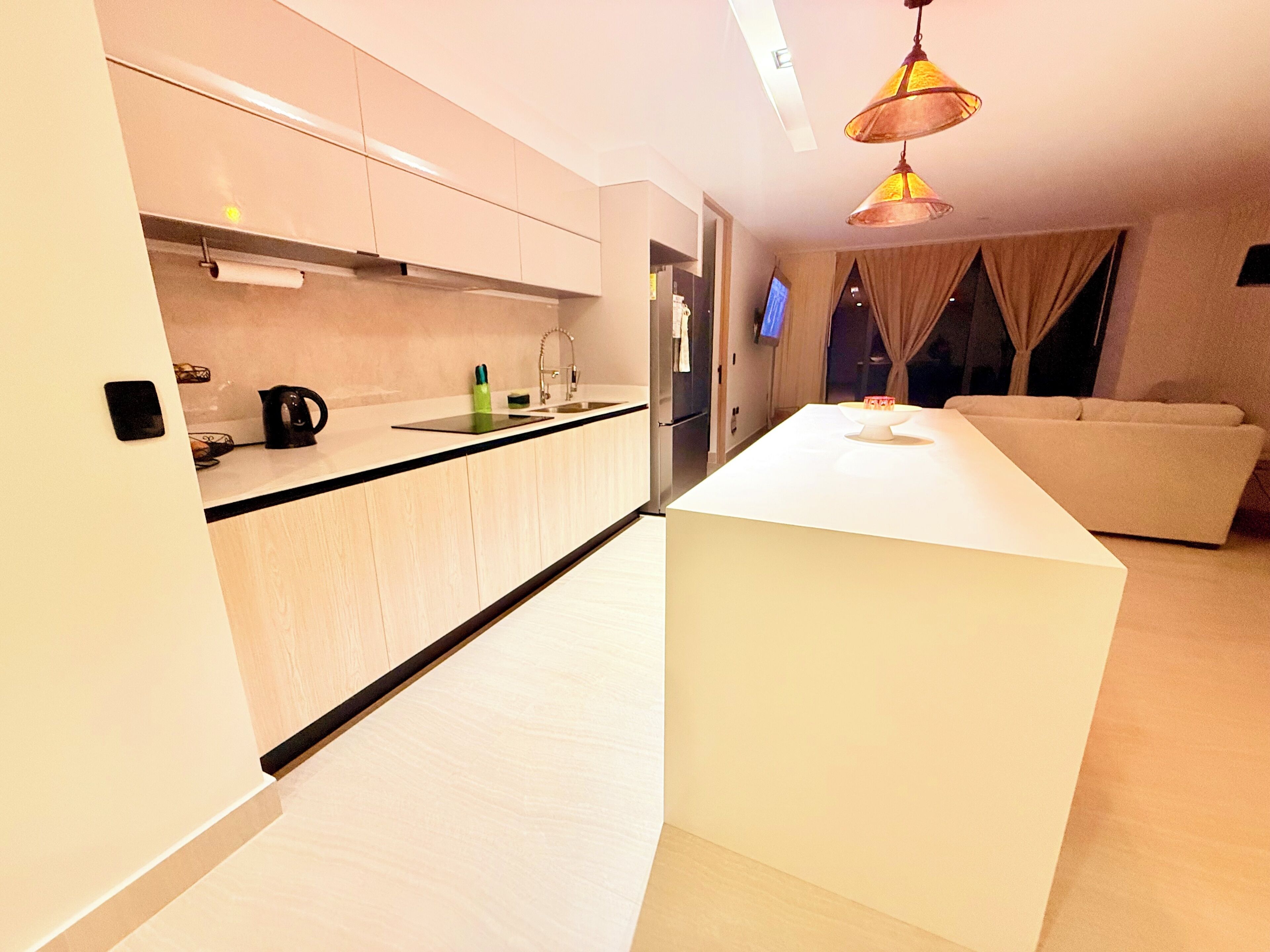 A modern kitchen with a central island, a built-in oven, and a sink.
