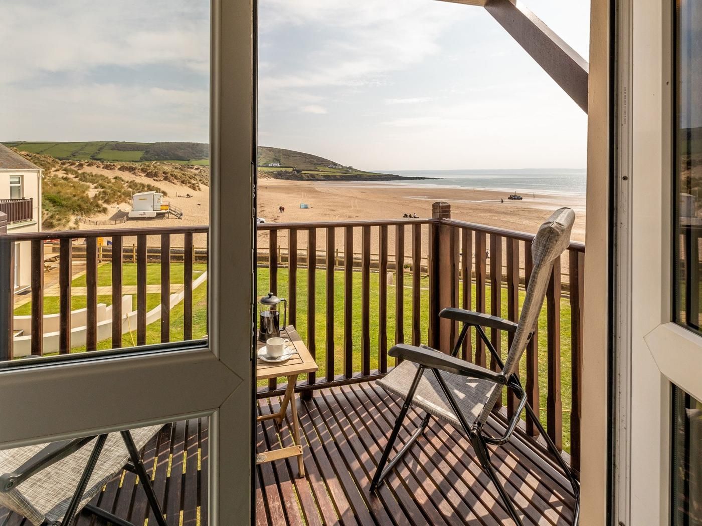 Un balcone con vista sulla spiaggia e sulle colline.