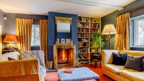 Ein gemütliches Wohnzimmer mit Kamin, Bücherregal und zwei Sofas.