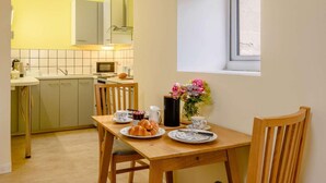 Una cucina compatta con zona pranzo, una finestra vista e un tavolo apparecchiato per la colazione.
