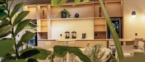 Un intérieur moderne avec un espace cuisine comprenant des meubles de rangement en bois, une table ronde et des chaises.
