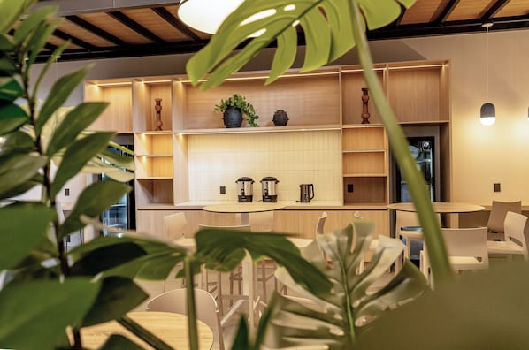 A modern interior with a kitchen area featuring wooden cabinets, a round table, and chairs.