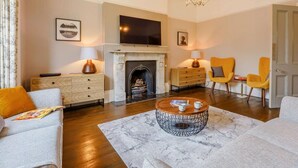 A living room with a fireplace, a television, and modern furniture. - 5 Bed in Sandown (oc-87008) (Sandown)